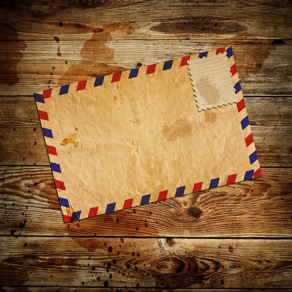 Enveloppe vintage avec timbre blanc sur fond en bois — Photo