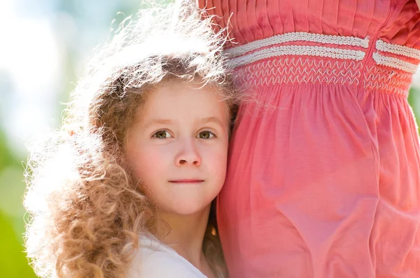 Schöne kleine Tochter umarmt ihre Mutter — Stockfoto