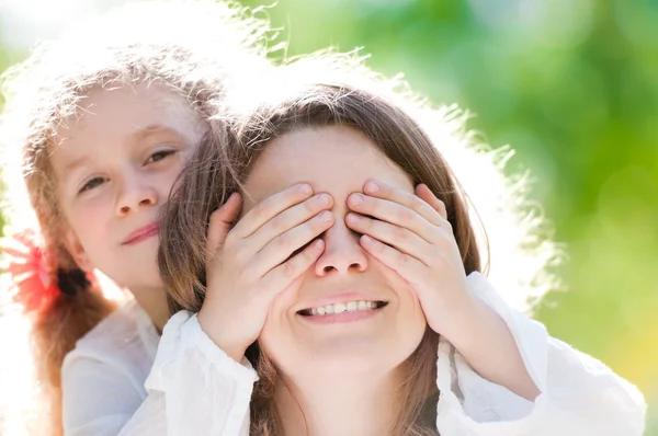 Krásná holčička s rukou na oči matky — Stock fotografie