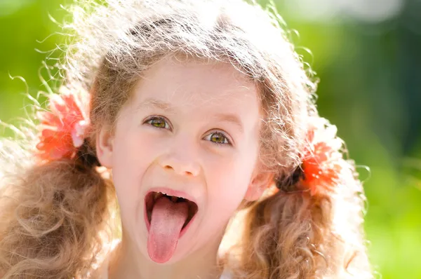 Красивая маленькая девочка показывает язык — стоковое фото