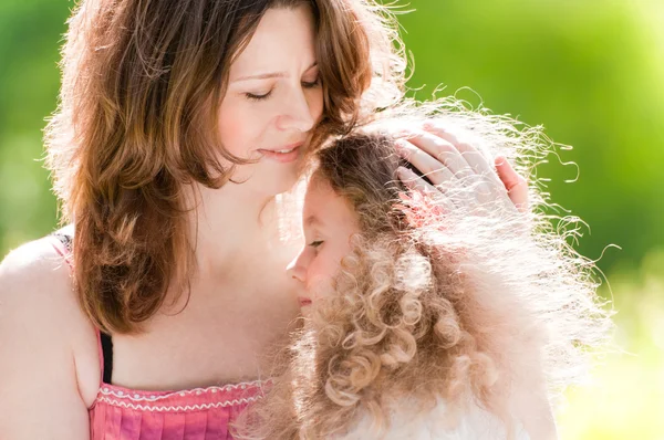 Jovem mãe abraçando sua filha — Fotografia de Stock