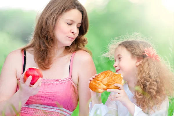 Young mother and her daughter eating — Stock Photo, Image