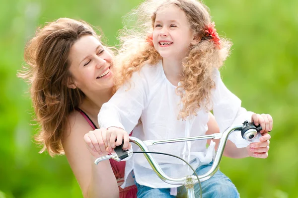 Młoda matka z córką na rowerze — Zdjęcie stockowe