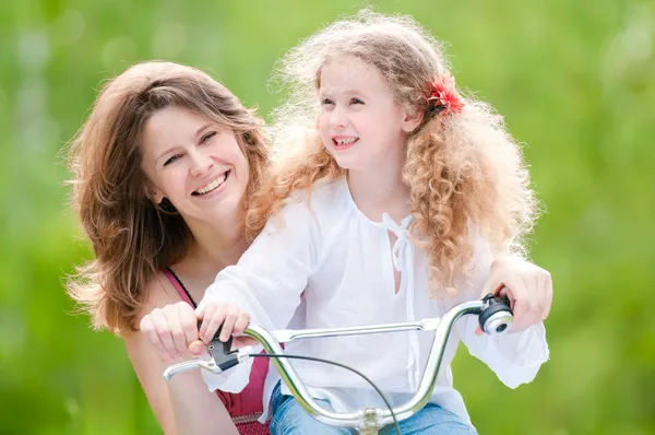 Genç anne ve kızı bisiklet üzerinde — Stok fotoğraf