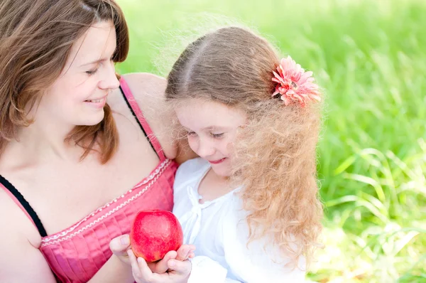 Giovane madre e sua figlia con mela — Foto Stock
