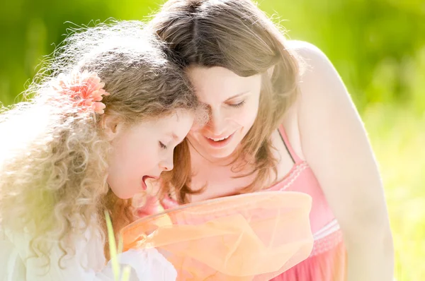 Kleines Mädchen und ihre Mutter mit Schmetterlingsnetz — Stockfoto