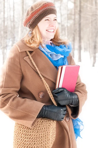 Ung kvinna med böcker på vintern — Stockfoto