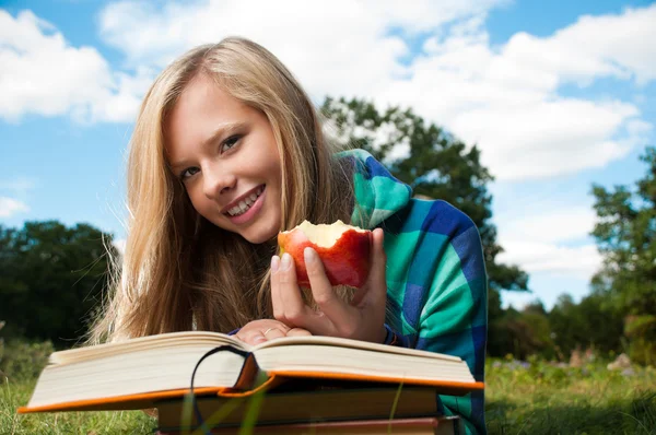 Schülerin mit Apfel und Büchern — Stockfoto
