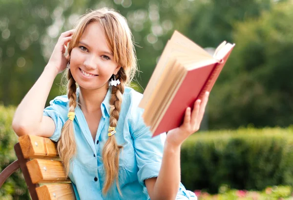Schöne junge Studentin liest Buch — Stockfoto