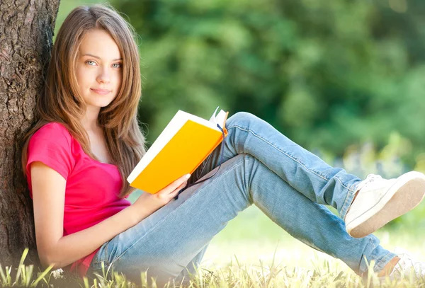 Glückliche junge Studentin mit Buch — Stockfoto