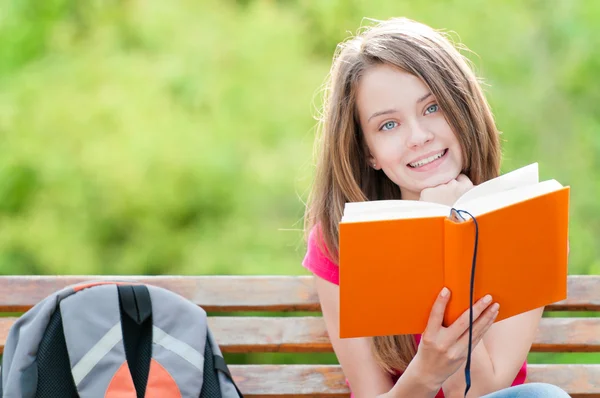 快乐的学生女孩坐在长凳上的书 — 图库照片