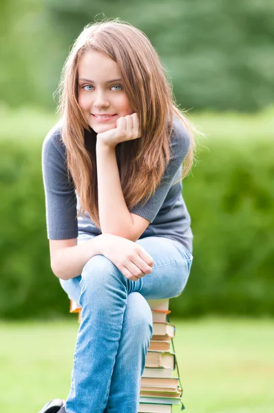 本に座っている幸せな学生の女の子 — ストック写真