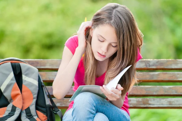 Young student girl sitting on bench — Stock Photo, Image