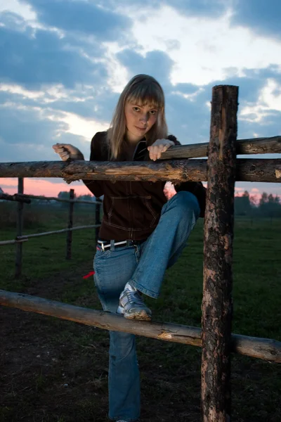 Girl standing near farm fence — Stock Photo, Image