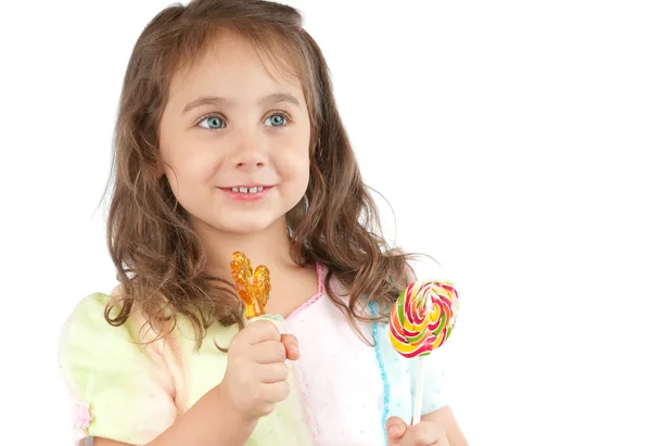 Happy little girl holding two candies in her hands — Stock Photo, Image