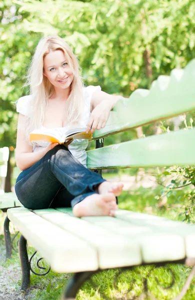 Jeune femme lecture livre dans le parc — Photo