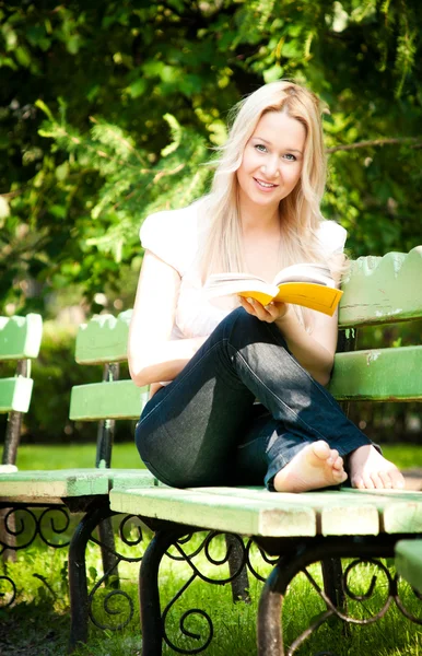 Fiatal nő olvasás könyv a parkban — Stock Fotó