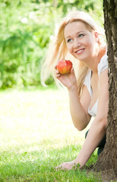 Mulher debaixo da árvore com maçã — Fotografia de Stock