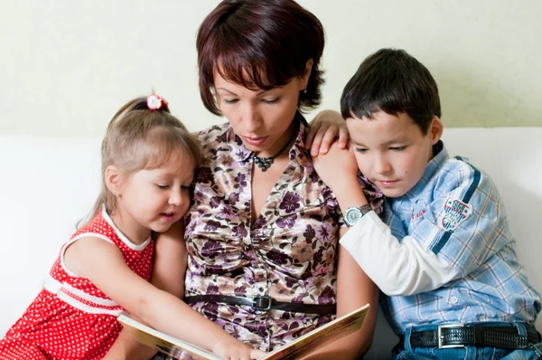 Uma mãe está lendo um livro para seus filhos — Fotografia de Stock
