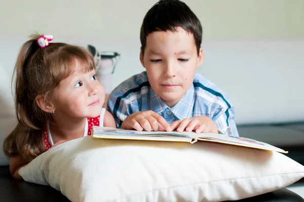 Jongen lezen van een boek naar zijn zus — Stockfoto