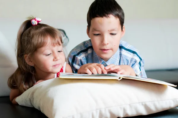 Garçon lisant un livre à sa sœur — Photo