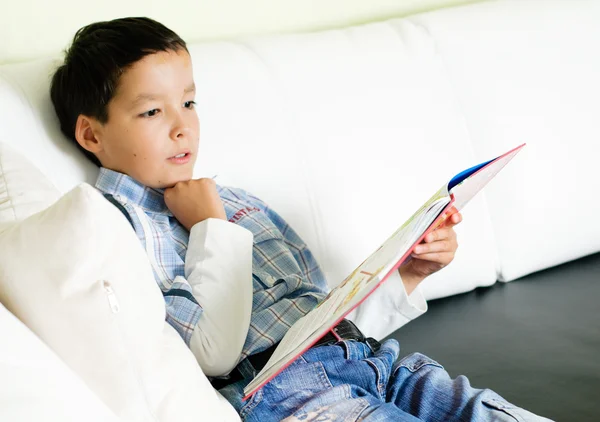 A fiú könyvet olvas. — Stock Fotó
