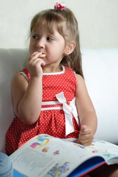 En liten flicka med en bok — Stockfoto