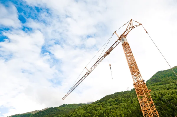 Construction crane in alps — Stock Photo, Image
