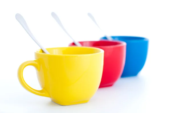 Три разноцветных чашки чая с ложками — стоковое фото