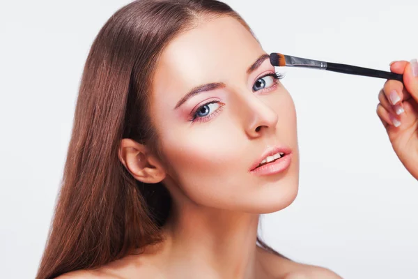 Wanita cantik menerapkan makeup mata merah muda — Stok Foto