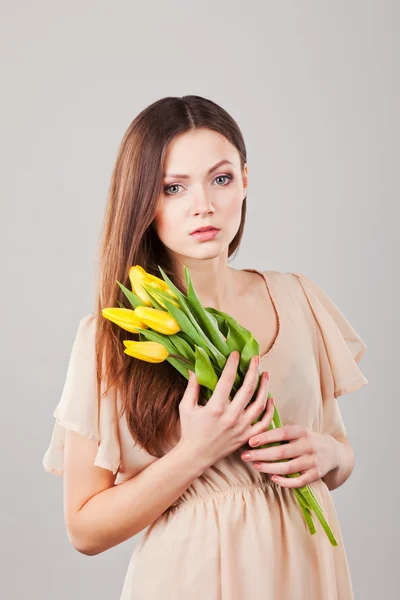 Porträt einer schönen Frau mit Tulpen — Stockfoto