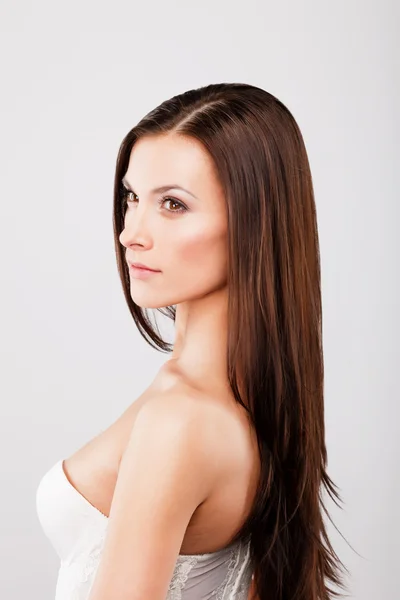 Brunette woman face vertical portrait over gray background — Stock Photo, Image
