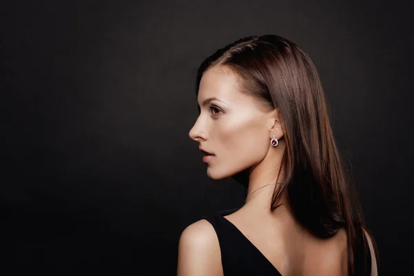 Brunette vrouw gezicht portret over donkere achtergrond — Stockfoto