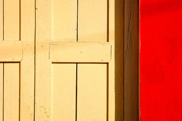 Röda väggen gul dörr — Stockfoto