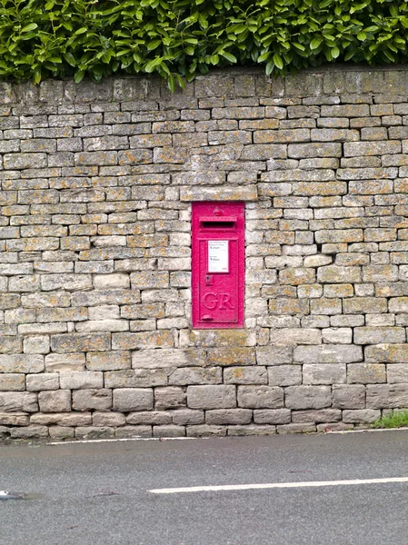 Red postbox in a wall — Stock Photo, Image