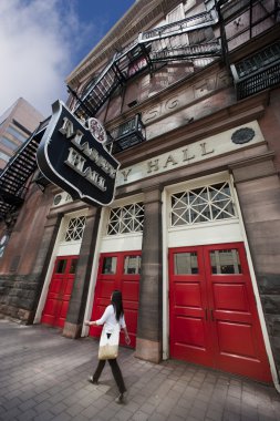 Woman walks past Massey Hall clipart