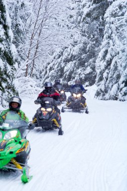 Snowmobilers on a trail clipart