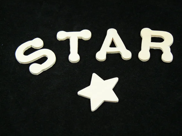 Een ster en het woord gespeld uit — Stockfoto