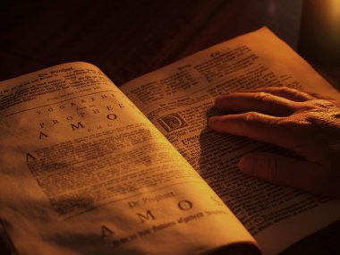 Old bible by candlelight clipart