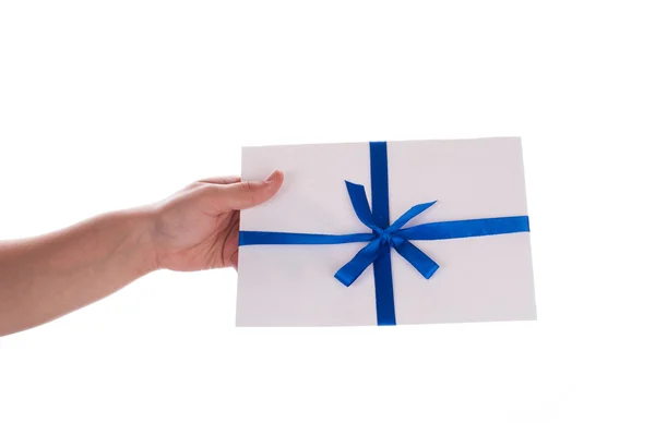 Ein Umschlag mit einem dünnen blauen Band in den Händen isoliert auf weiß — Stockfoto
