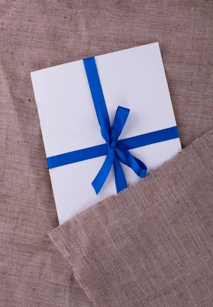 L'enveloppe attachée avec un ruban bleu sur le sac — Photo