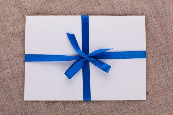 Der Umschlag mit einem blauen Band an der Verpackung gebunden — Stockfoto
