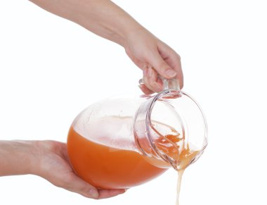 Hands of the girls poured from a carafe of fresh juice clipart