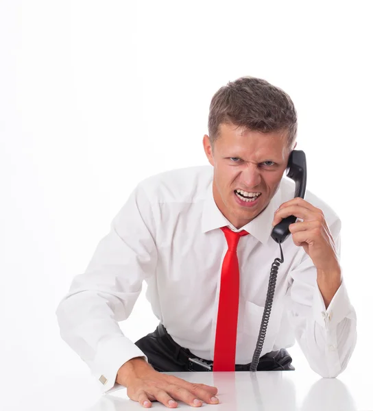 Homem de negócios irritado sentado em sua mesa e gritando — Fotografia de Stock