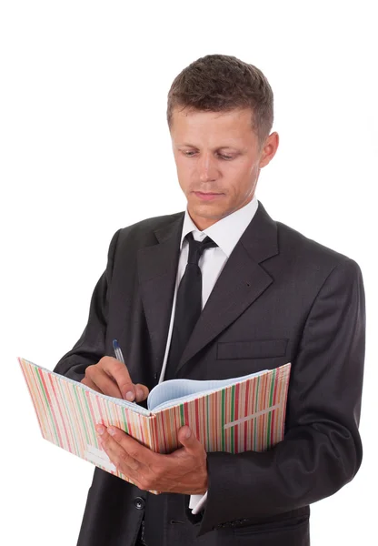 Uomo d'affari che scrive qualcosa su un quaderno — Foto Stock