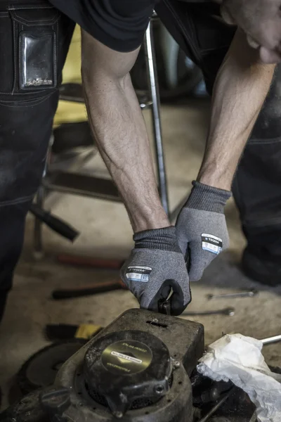 stock image Male arms repairing mower