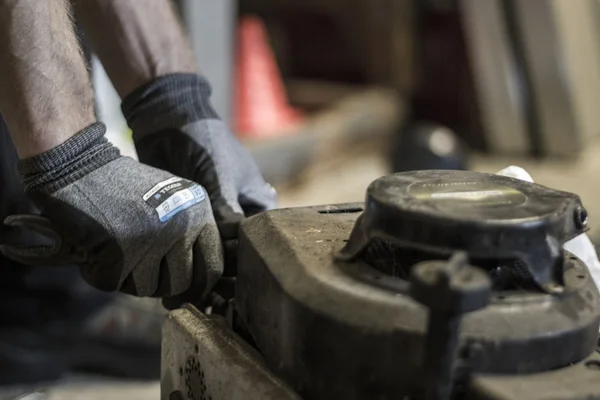 stock image Male arms repairing mower