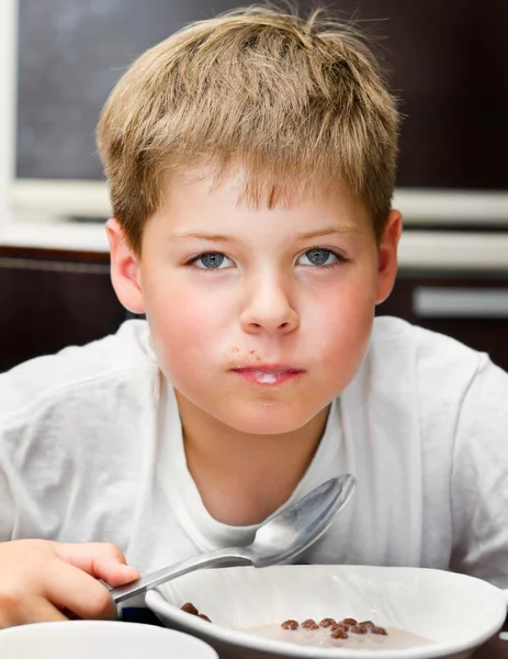 Boy eating chocolate cereal balls — Stock Photo, Image