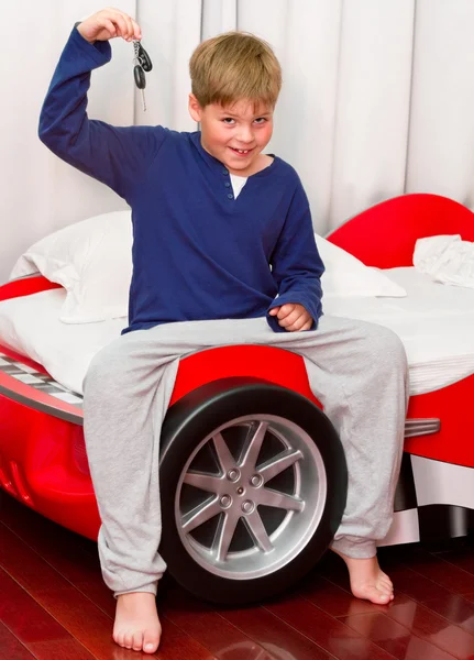 소년과 키와 그의 supercar 침대 로열티 프리 스톡 이미지