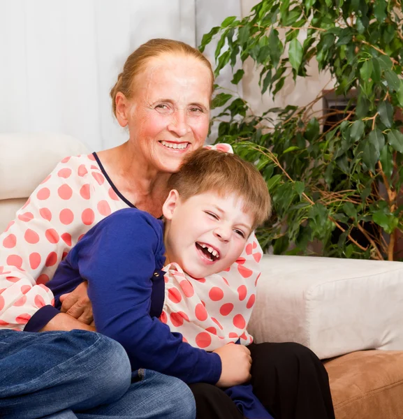 Lachen kleinzoon hugs met grootmoeder — Stockfoto